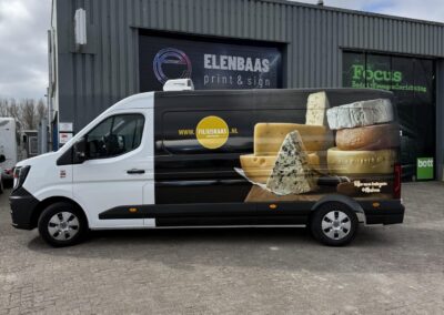 Linkerzijaanzicht van volledig wrap bestelwagen voor Filius Kaas, met grote fotoprint van diverse kazen en logo, uitgevoerd bij Elenbaas Print & Sign.